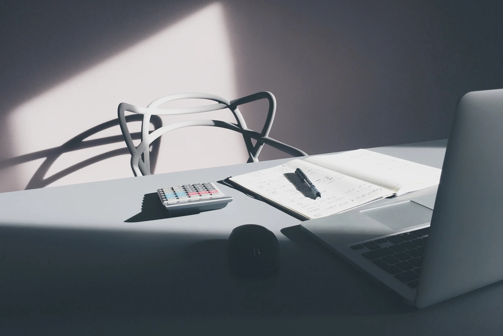 Calculator, pen and paperwork on a desk